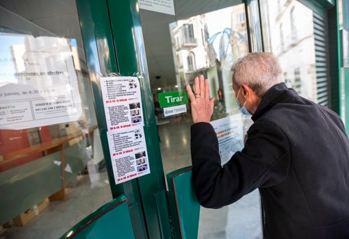 Un usuario se asoma a una de las oficinas cerradas en el centro de Málaga