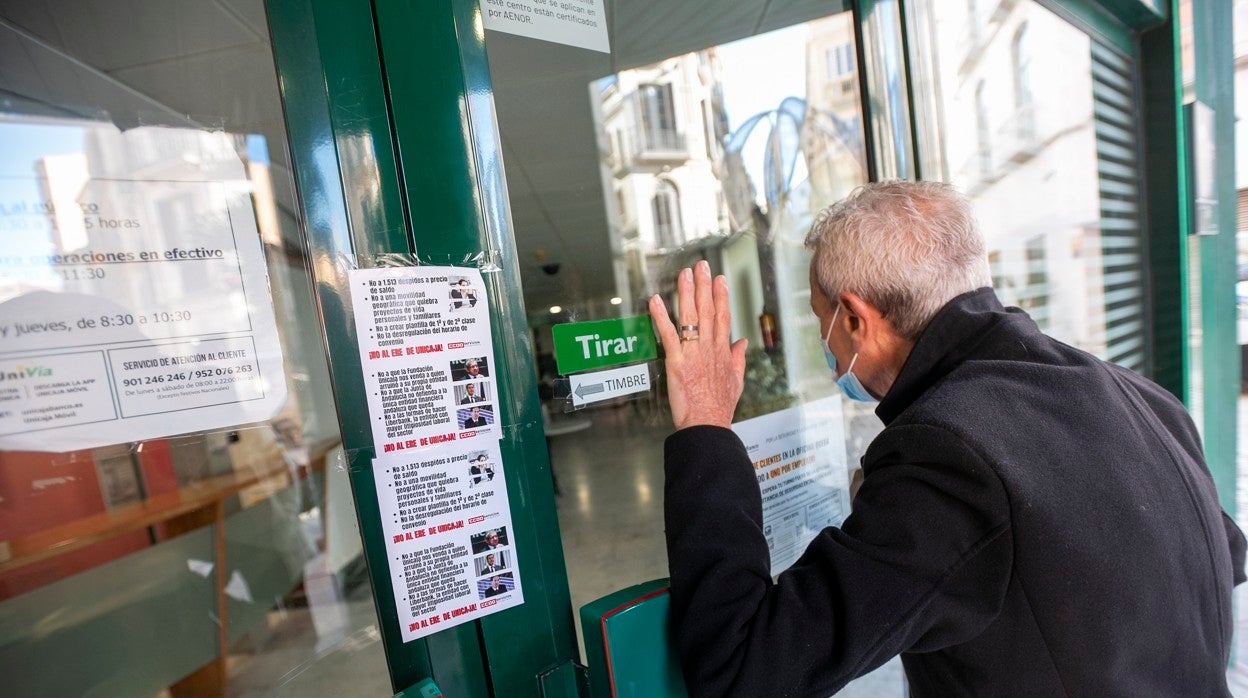 Un hombre trata de acceder ayer viernes a una sucursal de Unicaja cerrada por la huelga