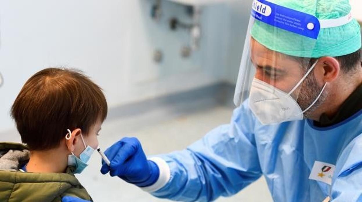 Un sanitario hace una PCR a un niño