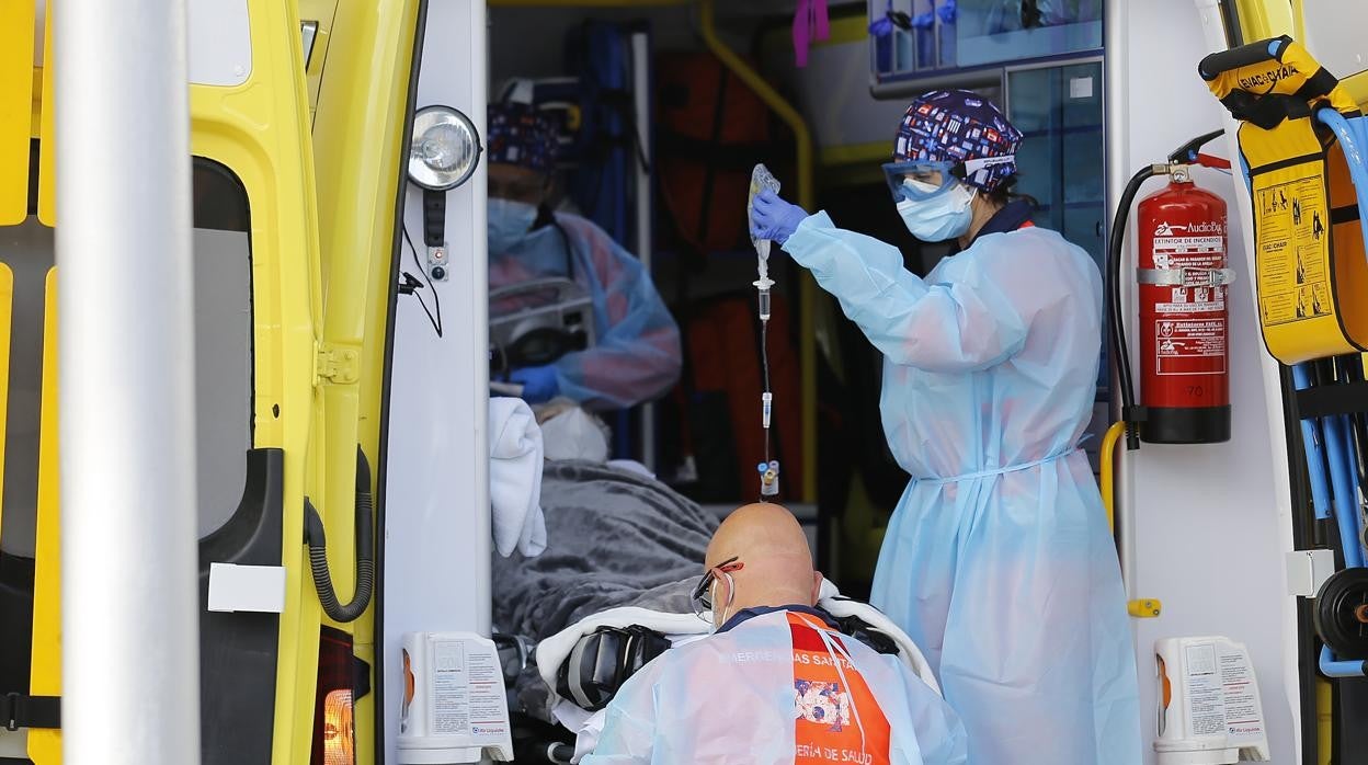 Sanitarios bajan a un paciente de una ambulancia en la entrada de Urgencias del Hospital Reina Sofía de Córdoba