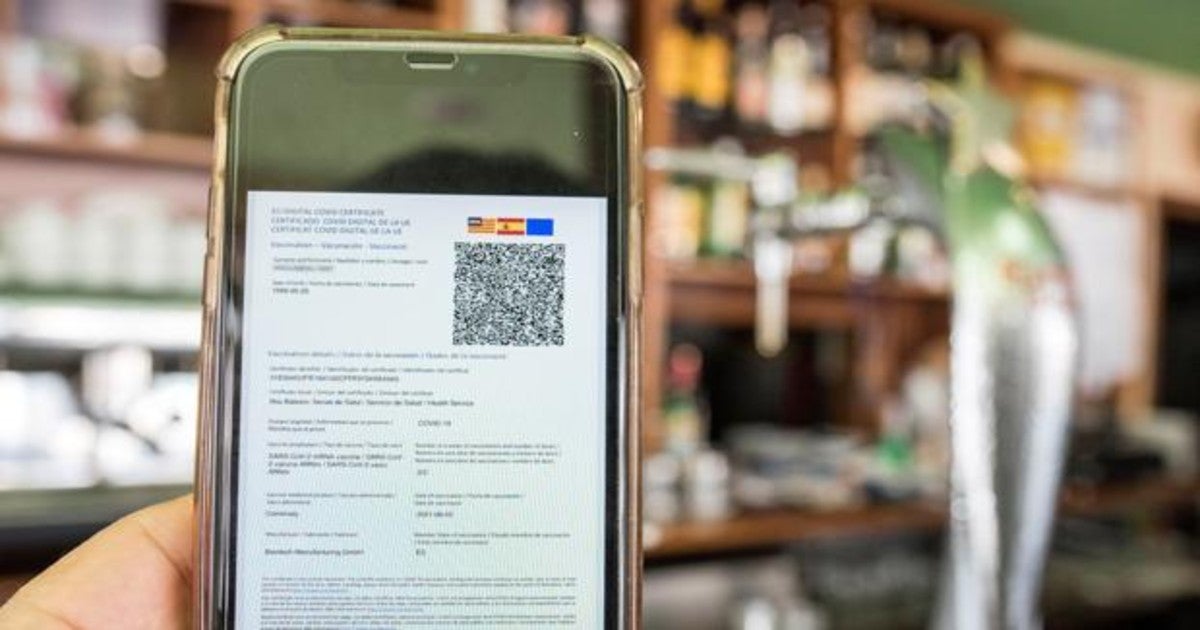 Un cliente de un bar muestra en su móvil el certificado Covid