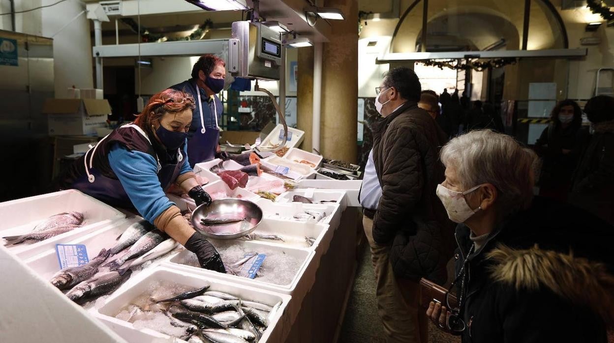 Clientes ante un puesto del mercado de La Corredera