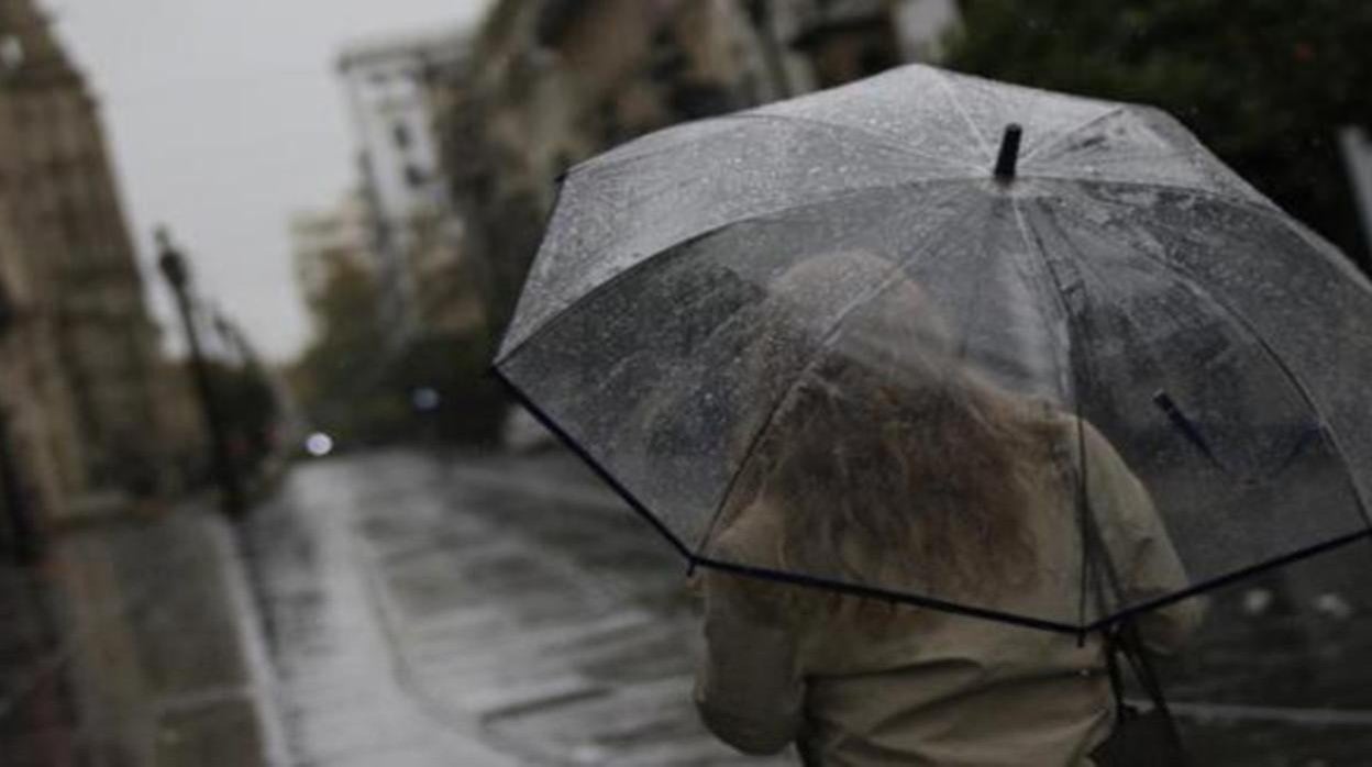 Una joven se protege de la lluvia con su paraguas