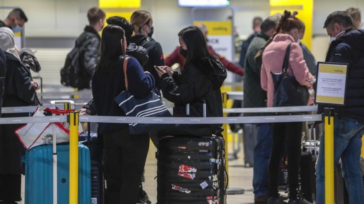 Turistas guardan cola en el aeropuerto de Sevilla