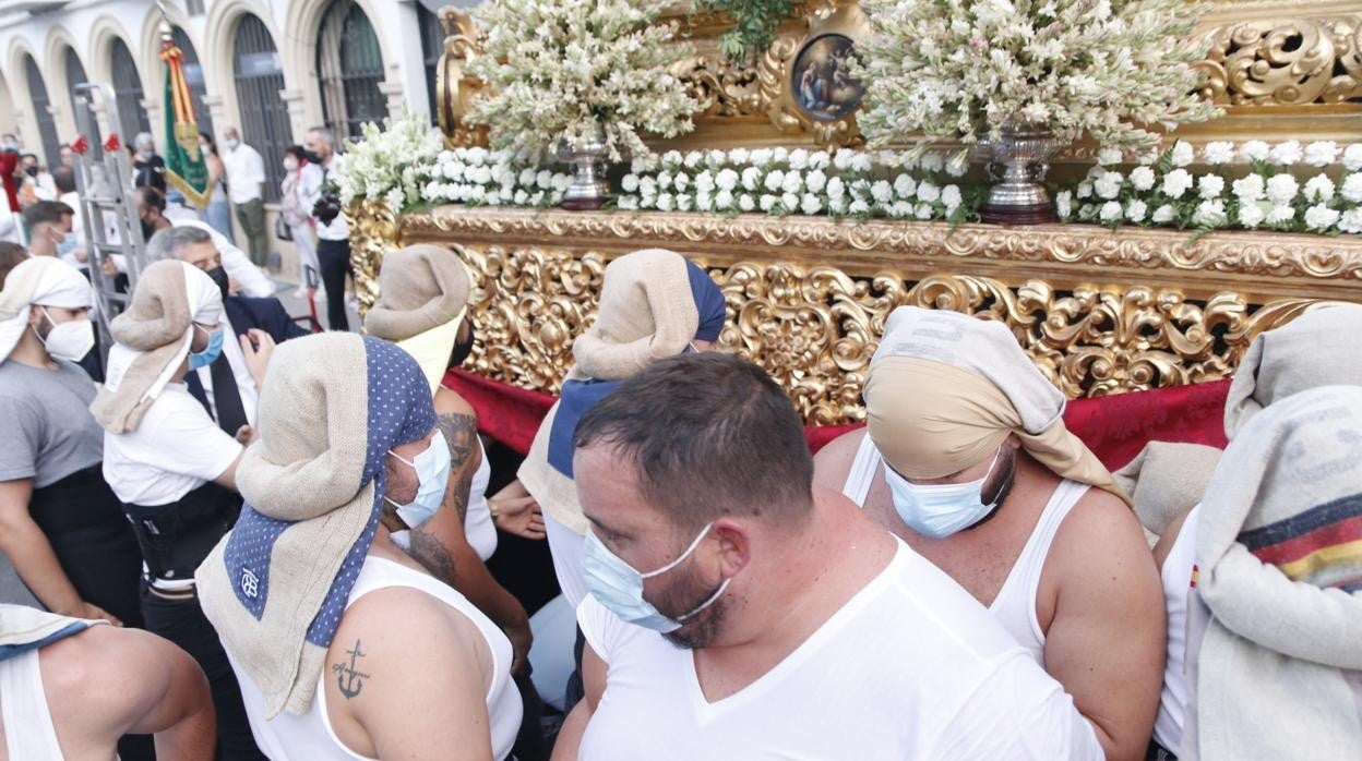 Costaleros con mascarillas en un relevo del paso de la Divina Pastora de Capuchinos