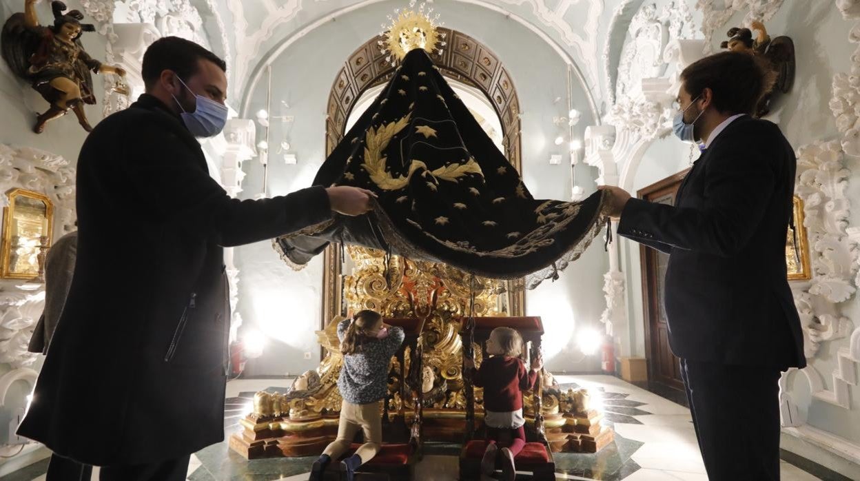 Dos niños, bajo el manto de la Virgen de los Dolores, el miércoles por la tarde