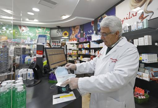 Un farmacéutico muestra una caja de mascarillas