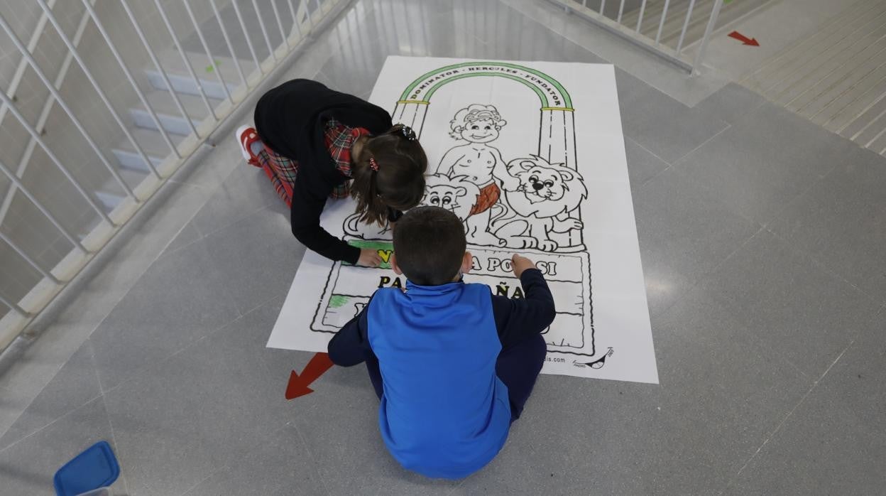 Dos niños colorean un dibujo, con motivo del Día de Andalucía, en el colegio Turruñuelos de Córdoba