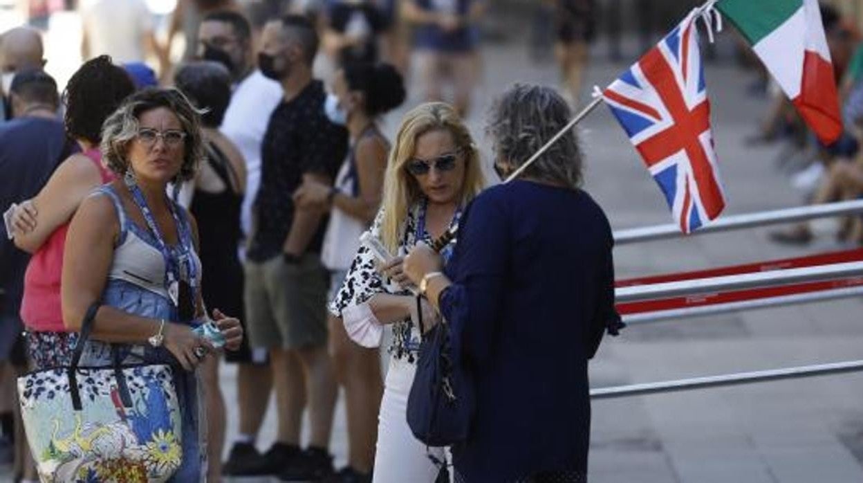 Dos turistas atienden las explicaciones de una guía en varios idiomas en la entrada de la Mezquita-Catedral, en diciembre de 2021