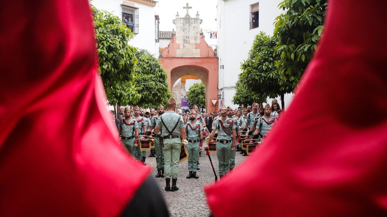 Miembros del Tercio Gran Capitán de la Legión, en el Compás de San Francisco, ante dos nazarenos de la Caridad