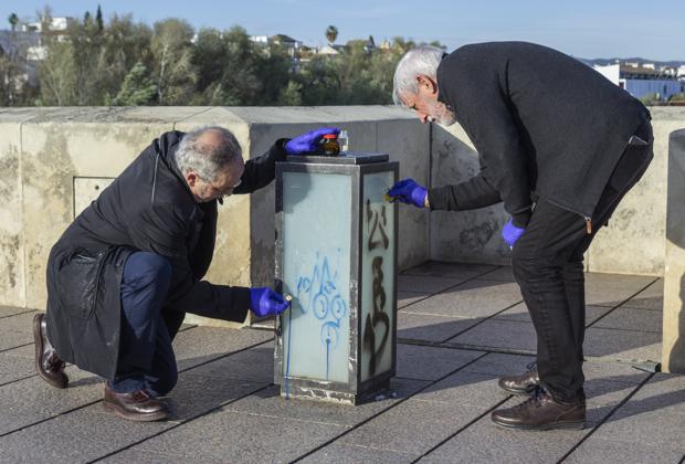 Vecinos de la Axerquía limpian grafitis de las farolas del Puente Romano de Córdoba