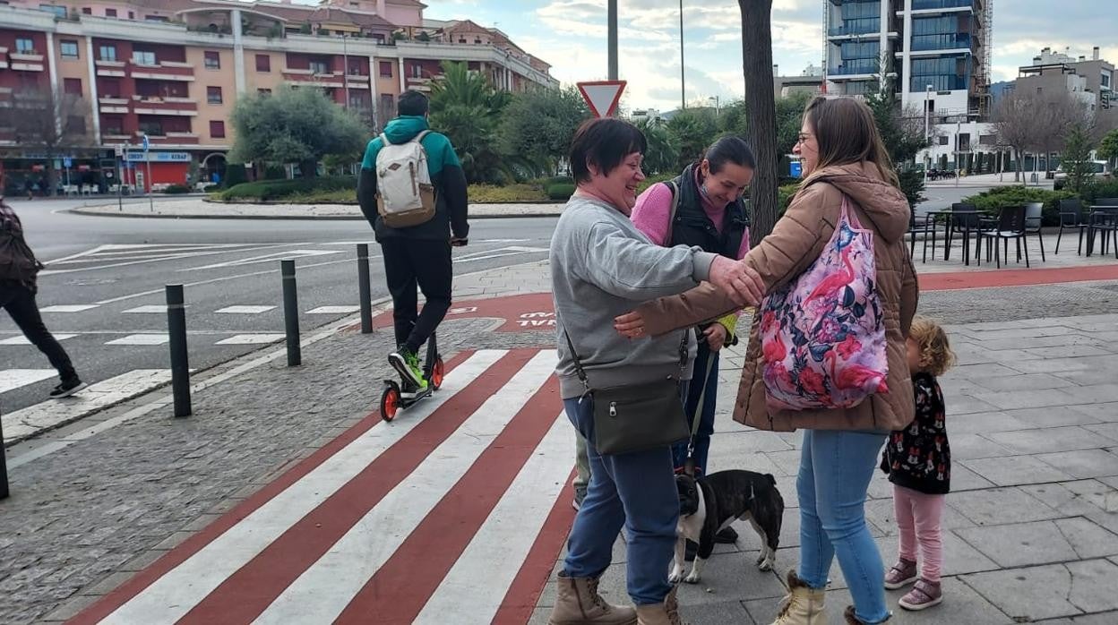 Nina y su hija Marta, a la izquierda, se encuentra este lunes con la vecina que la acoge en su casa