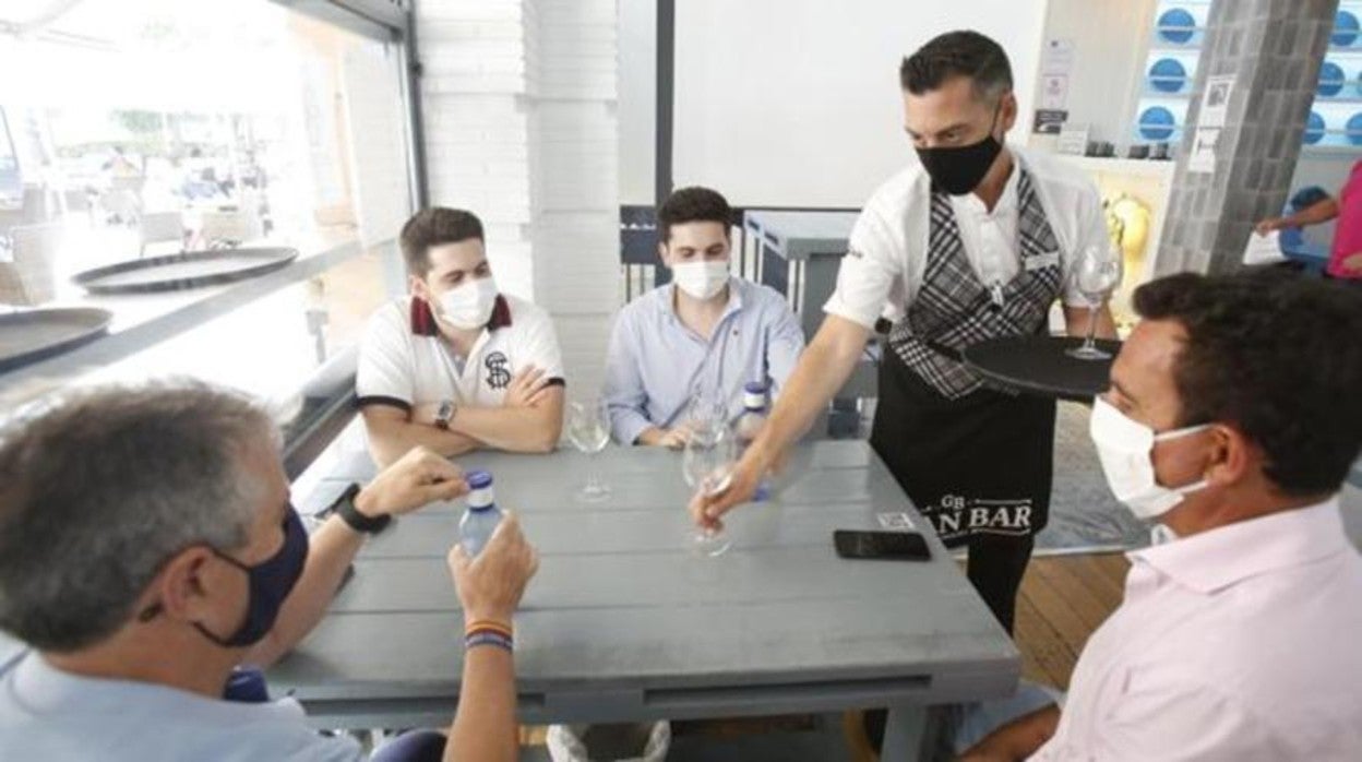 Clientes en un bar con la mascarilla puesta