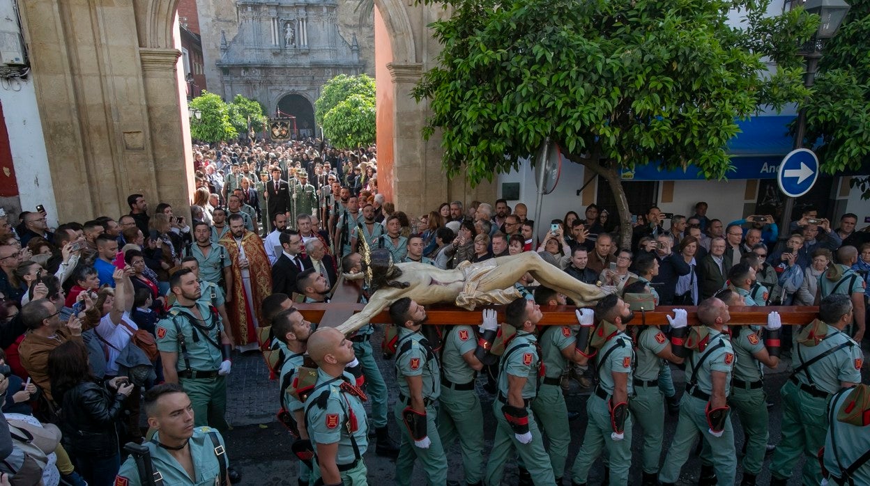 Los legionarios portan al Señor de la Caridad en el vía crucis del Viernes Santo