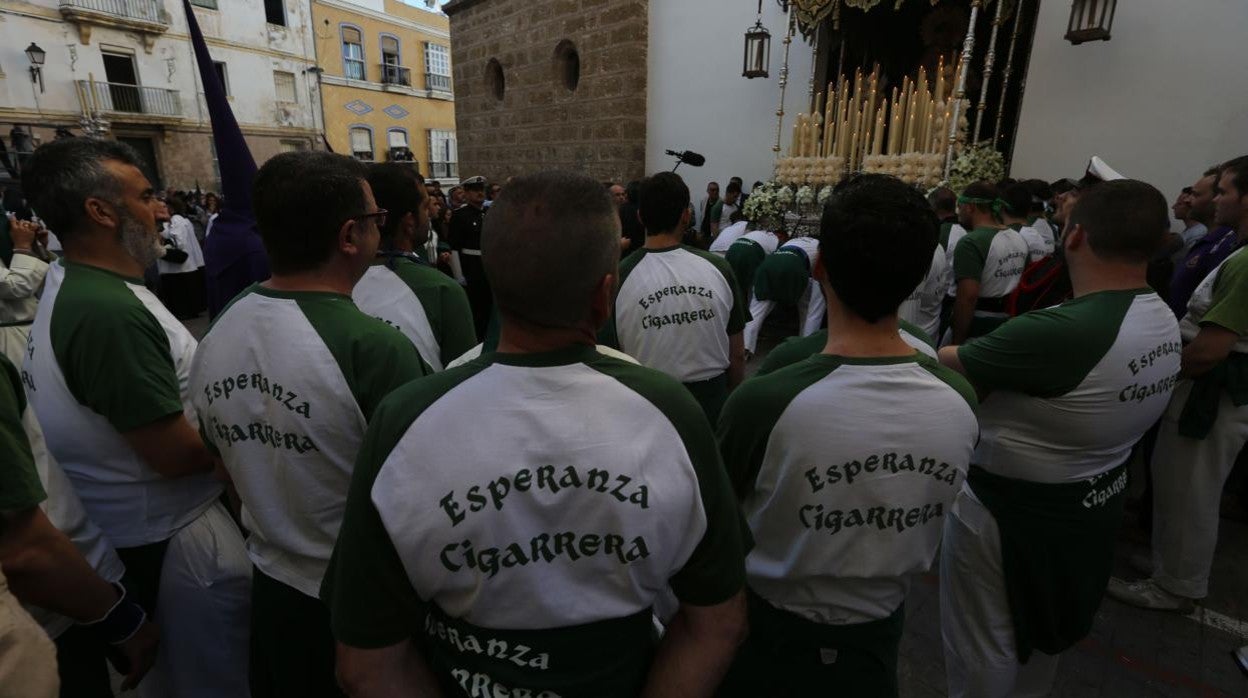 Varios hermanos cargadores observan la salida del palio de Cigarreras en una foto de archivo.