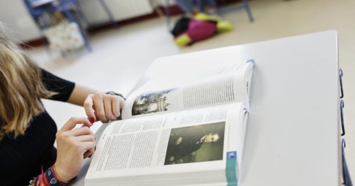 Una estudiante de Bachillerato frente a un libro de historia en su mesa