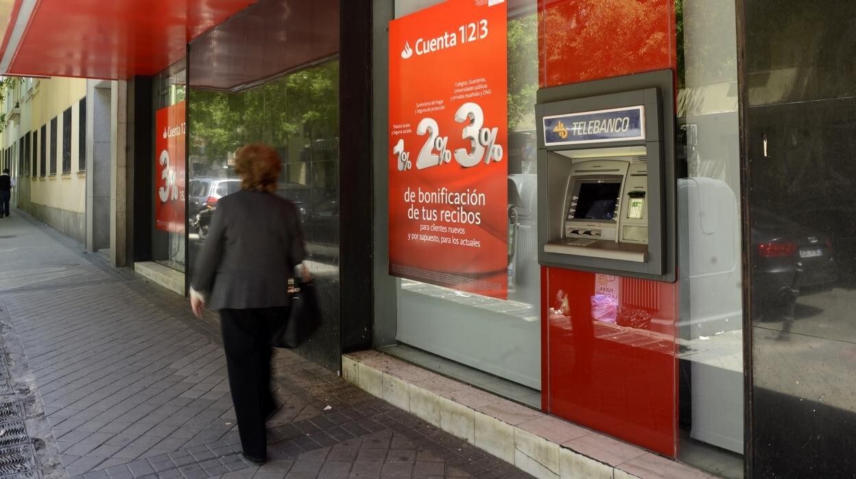 Una mujer pasa delante de una oficina del Banco Santander