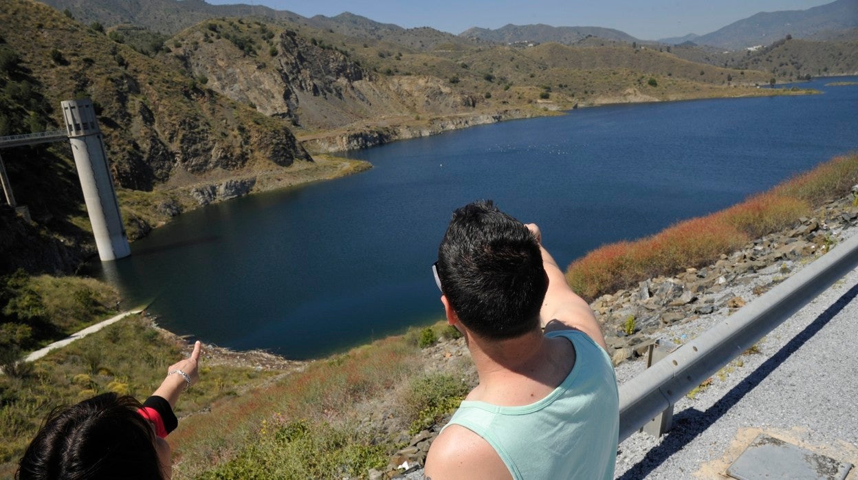 Unos paseantes señalan el embalse del limonero