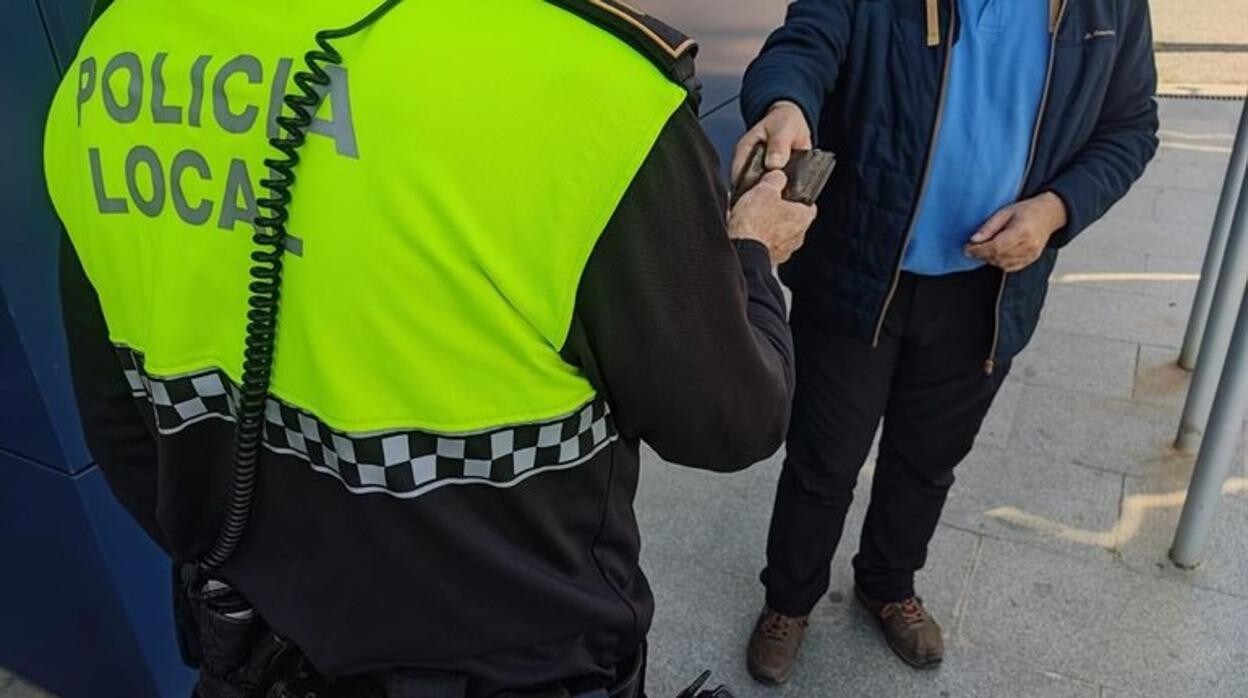 Un policía local entrega la cartera a su propietario