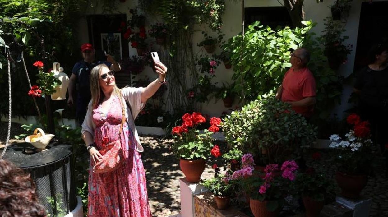 Una turista se hace un selife en un patio de la calle Parras