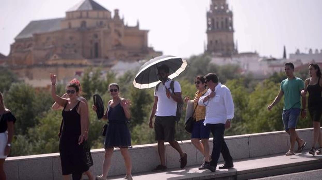 Viandantes protegiéndose del calor con un paraguas