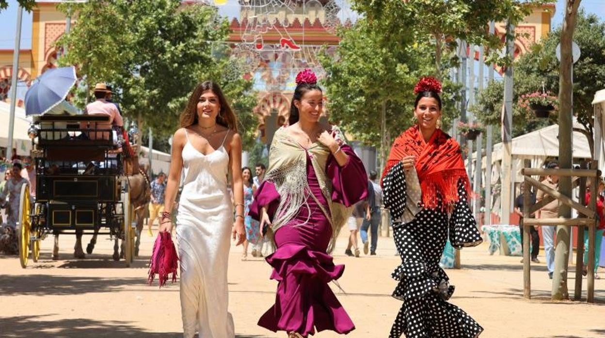 Tres jóvenes caminan por el real de la Feria el pasado lunes