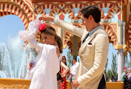 Una pareja baila junto a la portada de Feria