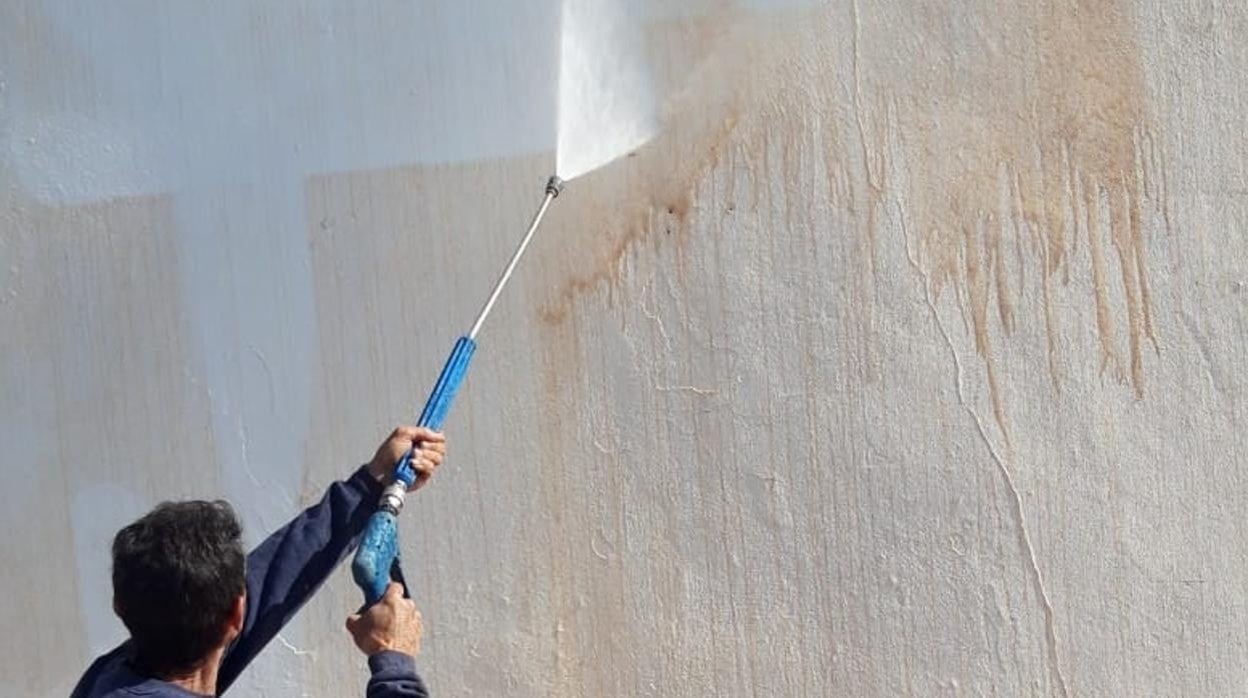 Un operario limpiando una pared en Frigiliana