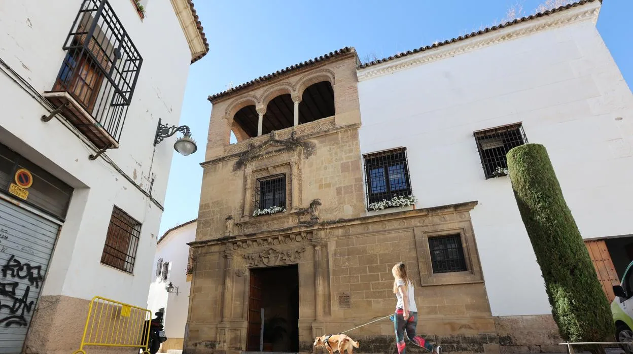 Una joven pasea a su perro delante del edificio histórico