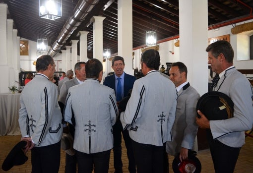 Juan Marín dialoga con los jinetes y docentes de la Real Escuela tras el acto