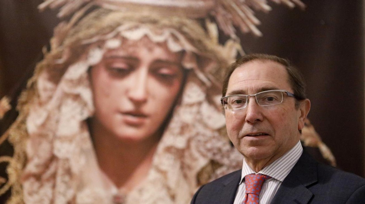 El hermano mayor de la Quinta Angustia, Rafael Jaén, con una fotografía de la Virgen al fondo