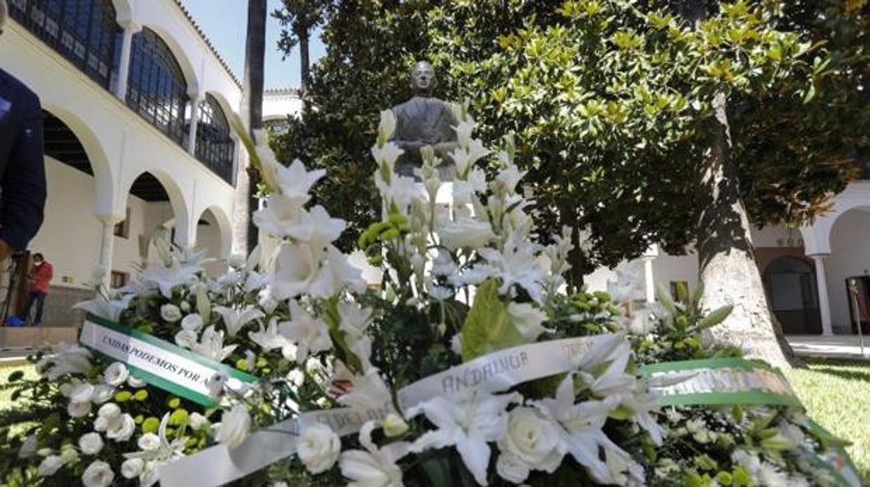 Flores ante la estatua de Blas Infante en el Parlamento de Andalucía