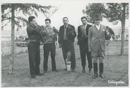 Cuatro aficionados con sus correspondientes pájaros oyen las instrucciones de Rodríguez de la Fuente (izda) en 1957