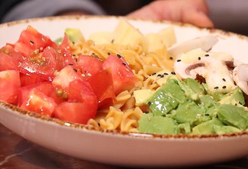 Emplatado de la ensalada de pasta de lentejas rojas, con aguacate, champiñones, tomate y lima.