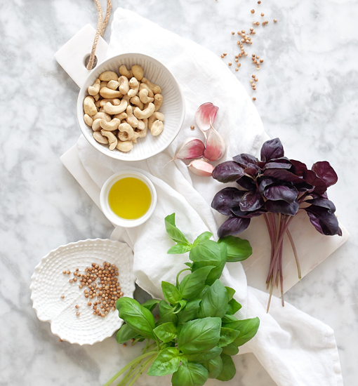 Bodegón de ingredientes para preparar la salsa de pesto de albahaca morada.