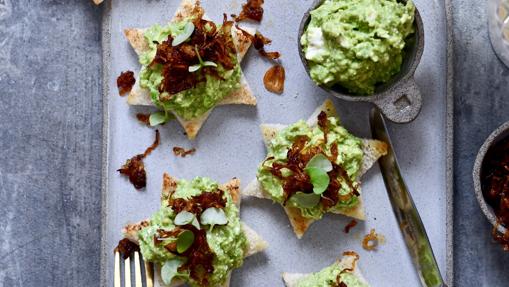 Crostini de guacamole con chalotas caramelizadas y queso feta.