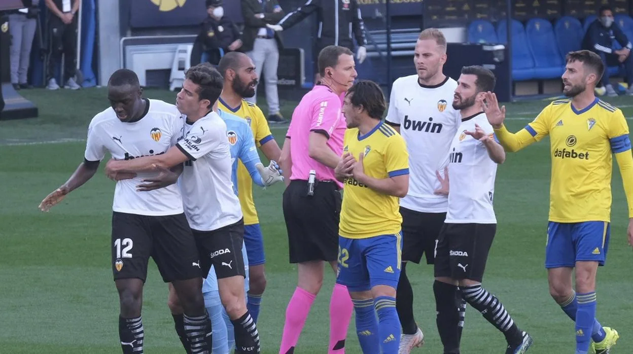 Diakhaby, sujetado por Paulista en presencia del árbitro y de varios jugadores del Cádiz.