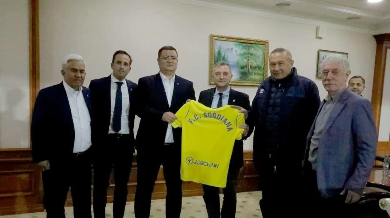 José luis donoso, con la camiseta del cádiz cf, entre los directivos del club local y Quique Pérez, el segundo por la izquierda..