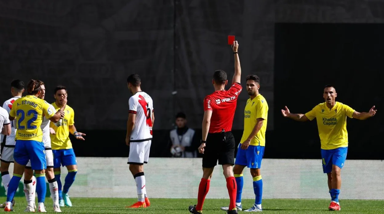 El árbitro Muñiz Ruiz muestra la tarjeta roja a Iza tras pitar penalti sobre Alvarito en Vallecas.