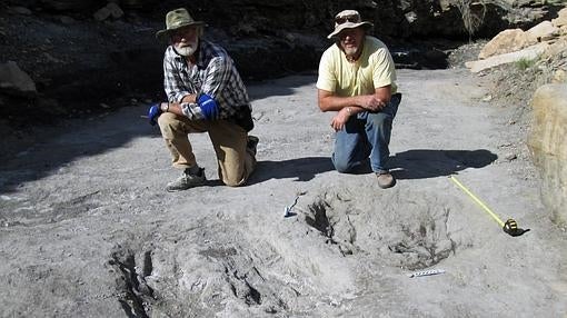 Martin Lockley (dcha.) posa junto a los arañazos de dinosaurio hallados en Colorado