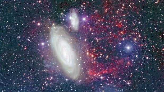 La galaxia en primer plano es NGC 4569 . Los filamentos de color rojo a la derecha muestran su cola