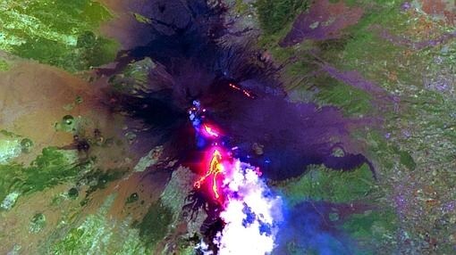 Erupción del Monte Etna de julio de 2001. La imagen muestra el avance de los flujos de lava en el flanco sur del volcán encima de la ciudad de Nicolosi. Las brillantes nubes hinchadas se forman a partir de vapor de agua liberado durante la erupción.
