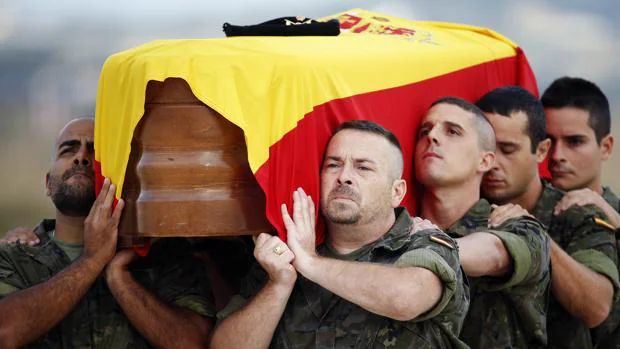 El féretro con los restos mortales de Aarón Vidal López, envuelto con la bandera nacional, es trasladado a hombros hasta el coche fúnebre a su llegada a la terminal militar del aeropuerto de Manises (Valencia)