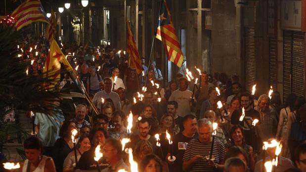 Simpatizantes de Esquerra Republicana de Catalunya se dirigen esta noche con antorchas a la Fossar de les Moreres, en Barcelona, para participar en la Vigilia de la Diada organizada por ERC-Barcelona Vella