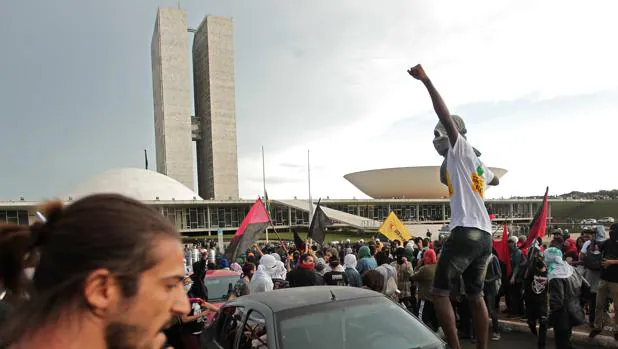 Un manifestante salta sobre un vehículo el pasado 29 de noviembre de 2016 frente al Congreso brasileño durante una protesta contra el ajuste fiscal que promueve Temer y por maniobras que puedan llevar a amnistiar a corruptos