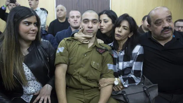 El soldado israelí Elor Azaria (c) espera junto a su familia a la lectura de la sentecia durante su juicio por disparar y matar a un atacante palestino reducido e inmovilizado