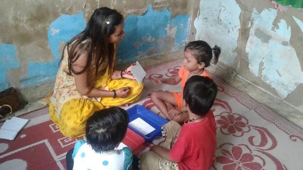 Una profesora y sus alumnos juegan a retos matemáticos en un centro preescolar de Dheli, en la India