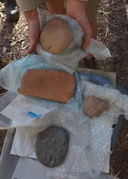 Tres hachas de diferentes capas del sitio y una piedra de afilar rectangular del nivel de 65.000 años