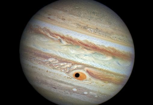 Imagen de Júpiter captada por el Hubble. La sombra de la luna Ganímedes pasa por la Gran Mancha Roja