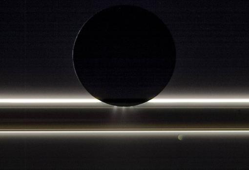 Encélado, la luna de Saturno, se desplaza ante los anillos y la pequeña luna Pandora en esta vista que la nave Cassini de la NASA capturó el 1 de noviembre de 2009